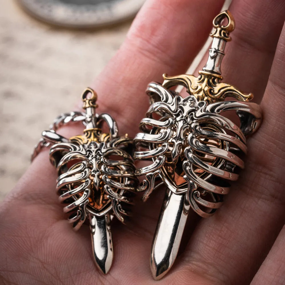 Two sizes of The Beating Heart Pendant showing the rib cage and sword details