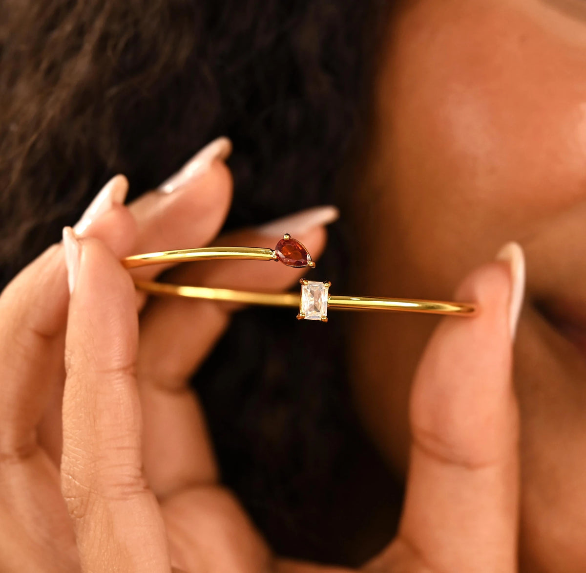 Close-up of the gold-tone bangle and its two crystal settings