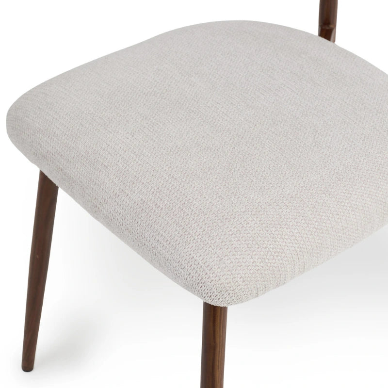 Close-up of the lightly textured grey fabric and padded dining chair seat