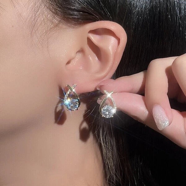 Mermaid tail stud earring worn on the ear with a matching earring held beside it