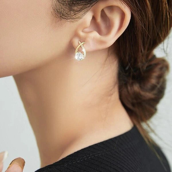 Gold tone mermaid tail stud earring worn with a black top