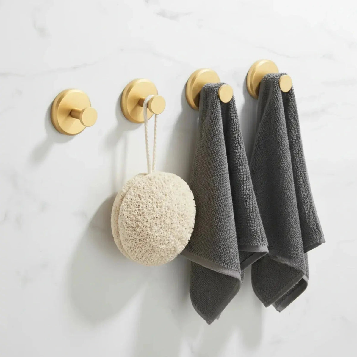 Set of four gold suction cup hooks shown on a bathroom wall