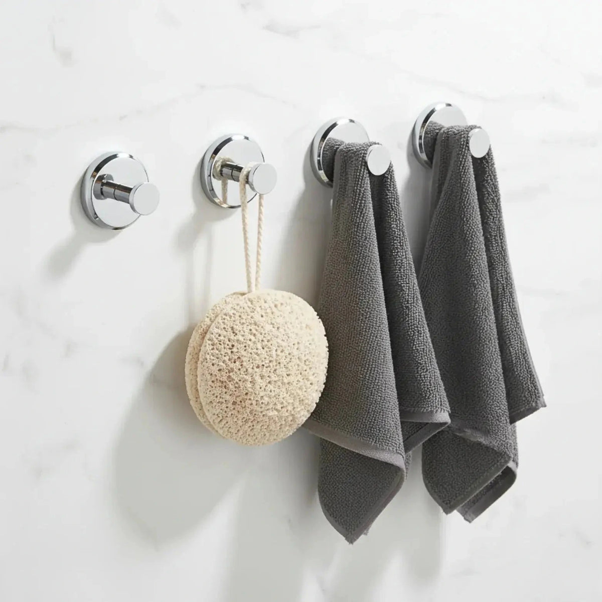Set of four silver suction cup hooks shown on a bathroom wall