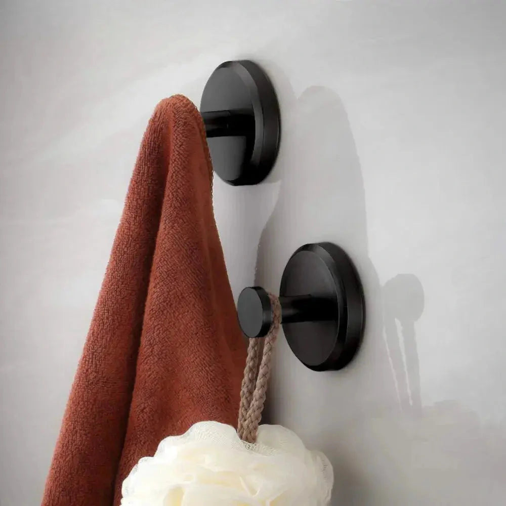 Black suction hooks used to hang a towel and bath sponge