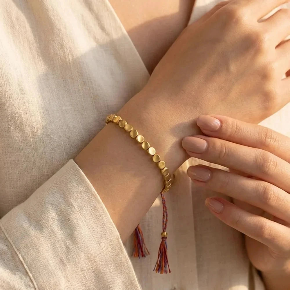 Adjustable metal bead bracelet styled with a light linen top