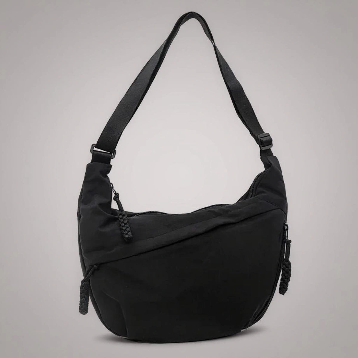 Black crossbody shoulder bag with zipped pockets and an adjustable strap