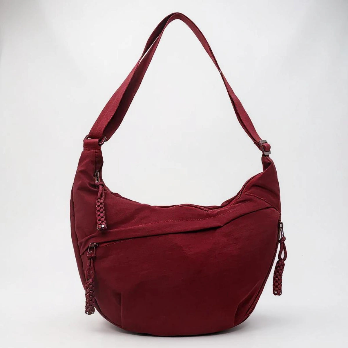 Burgundy crossbody shoulder bag with zipped pockets and an adjustable strap