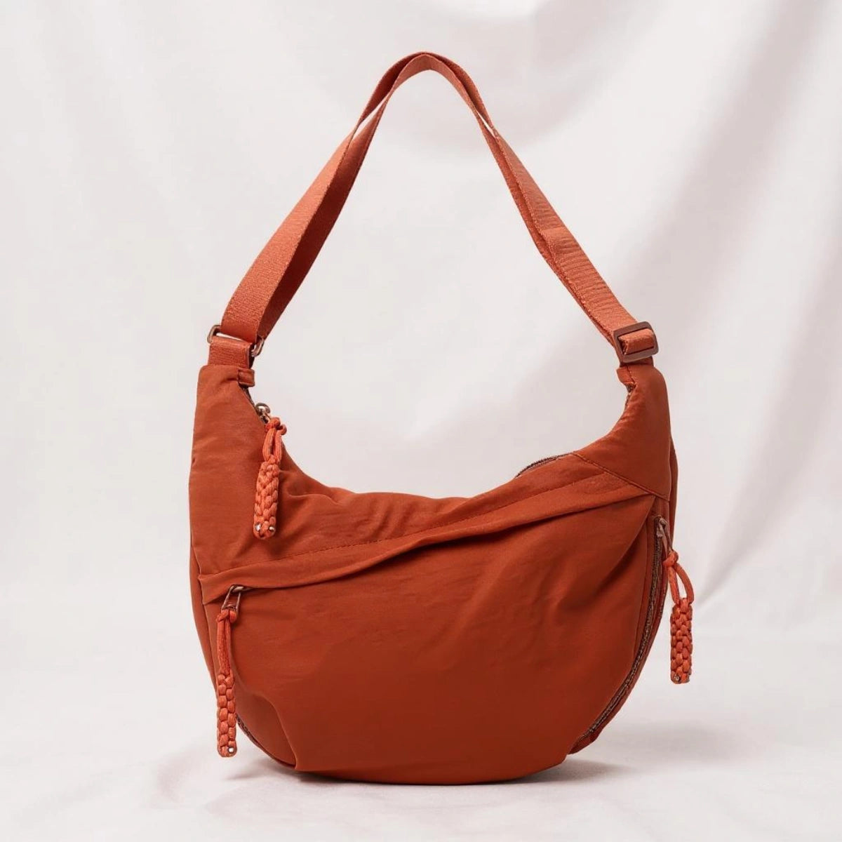 Orange crossbody shoulder bag with zipped pockets and an adjustable strap